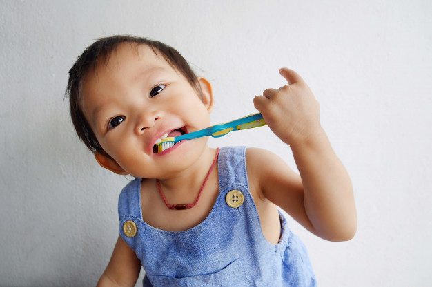 happy-asian-baby-girl-practice-brushing-her-teeth_75876-30